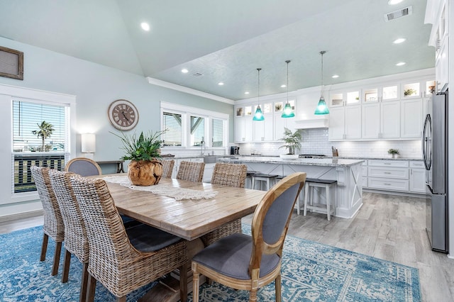 dining space featuring lofted ceiling and light wood-type flooring