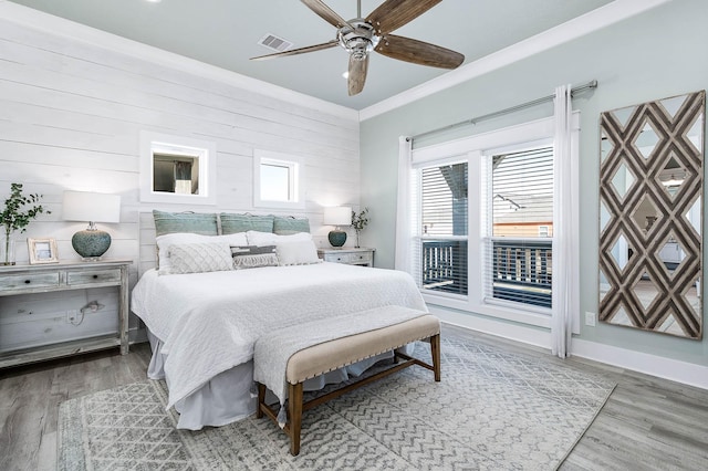 bedroom with access to exterior, crown molding, wood-type flooring, and ceiling fan