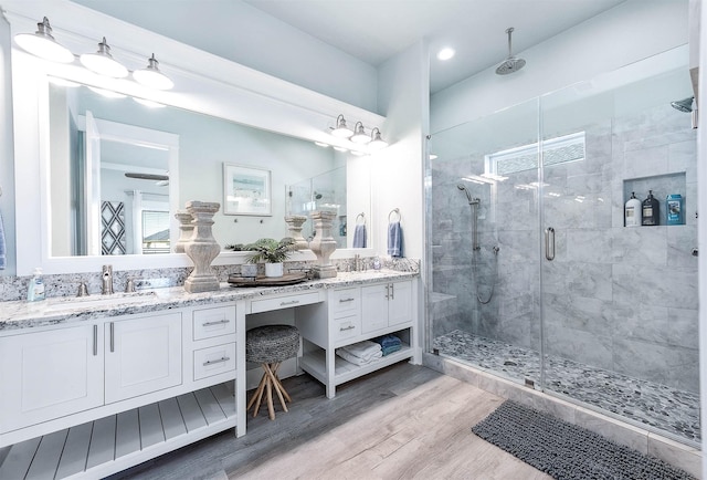 bathroom featuring walk in shower, vanity, and wood-type flooring