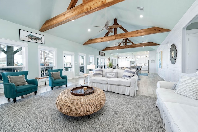 living room with hardwood / wood-style flooring, ceiling fan, high vaulted ceiling, and beam ceiling