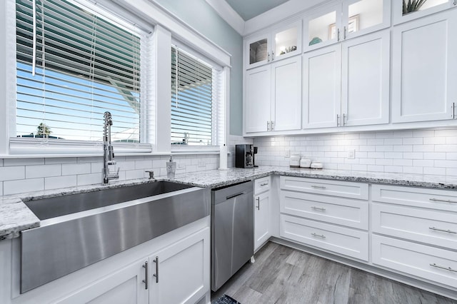 kitchen featuring sink, white cabinetry, light hardwood / wood-style flooring, dishwasher, and light stone countertops