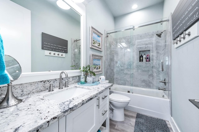 full bathroom featuring enclosed tub / shower combo, wood-type flooring, vanity, and toilet