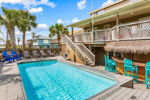 view of pool with a wooden deck and exterior bar