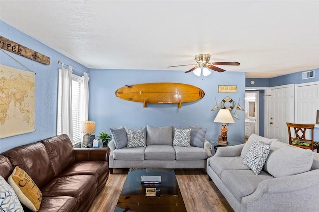 living room with dark hardwood / wood-style flooring and ceiling fan