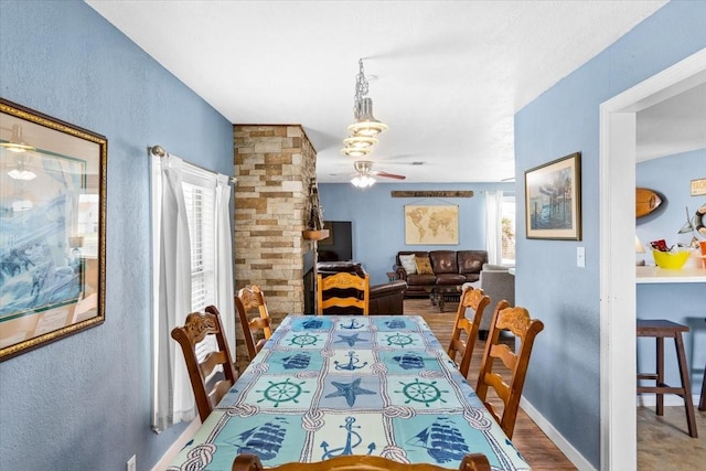 dining area featuring wood-type flooring and ceiling fan