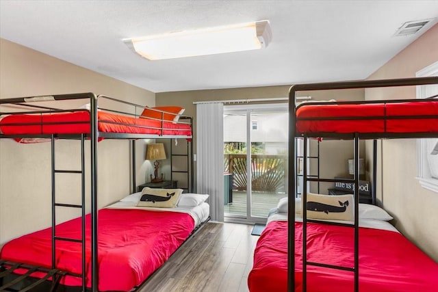 bedroom with dark wood-type flooring and access to outside