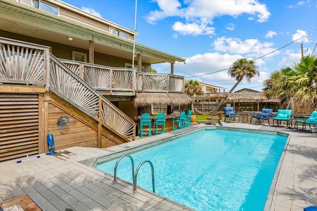 view of swimming pool with a wooden deck and an outdoor bar