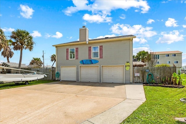 back of house with a yard and a garage