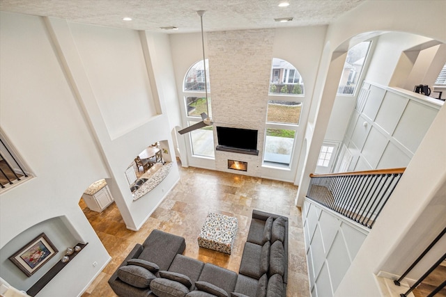 living room with a towering ceiling and a fireplace