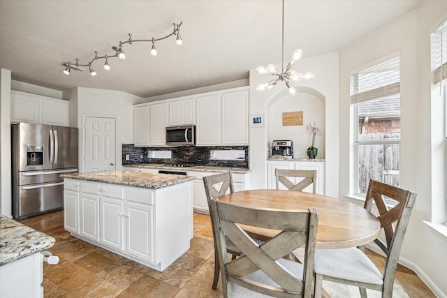 kitchen with stainless steel appliances, a center island, and white cabinets