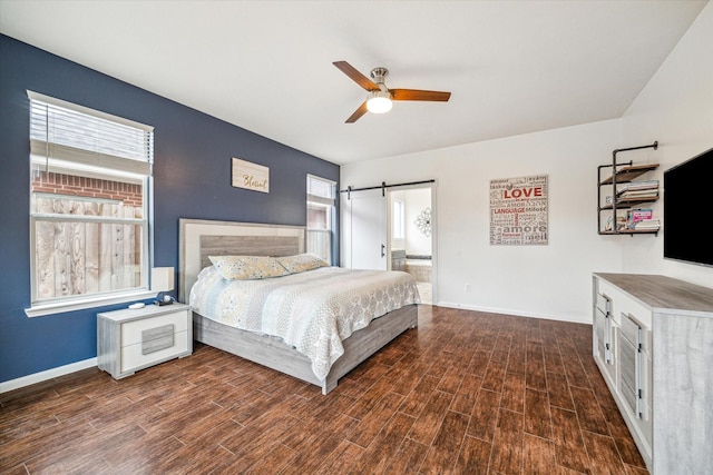 bedroom featuring ceiling fan and a barn door