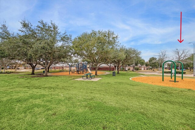 view of property's community with a playground and a lawn