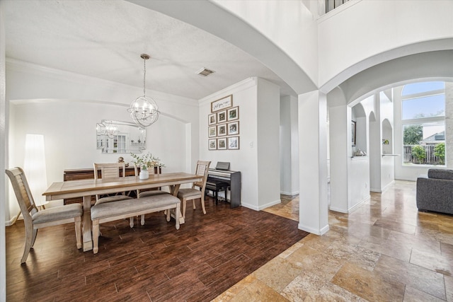 dining space with hardwood / wood-style flooring, crown molding, and a notable chandelier