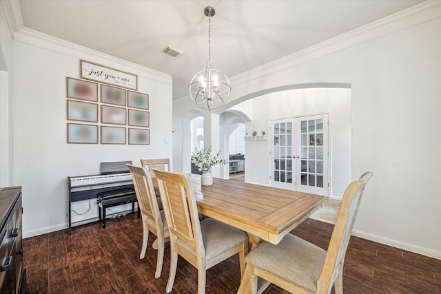 dining space featuring dark hardwood / wood-style flooring, crown molding, french doors, and a chandelier