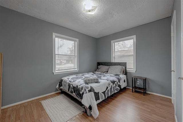 bedroom featuring light hardwood / wood-style floors and a textured ceiling