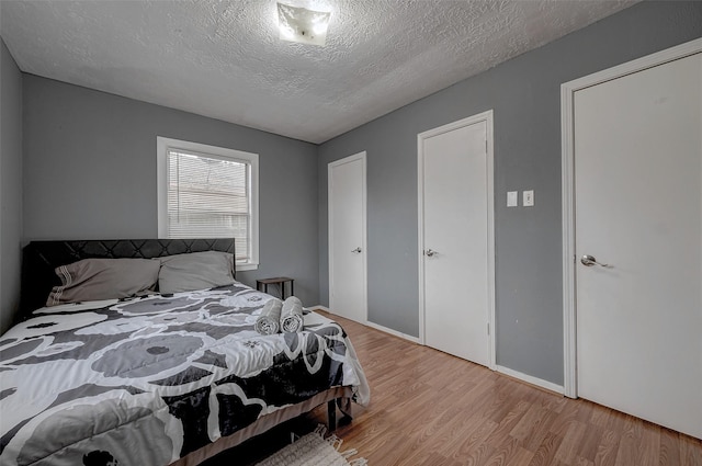 bedroom featuring light hardwood / wood-style floors and a textured ceiling