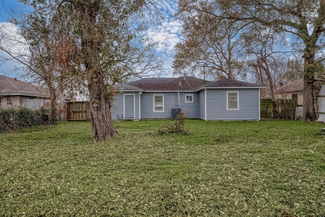 back of house with a lawn and central air condition unit