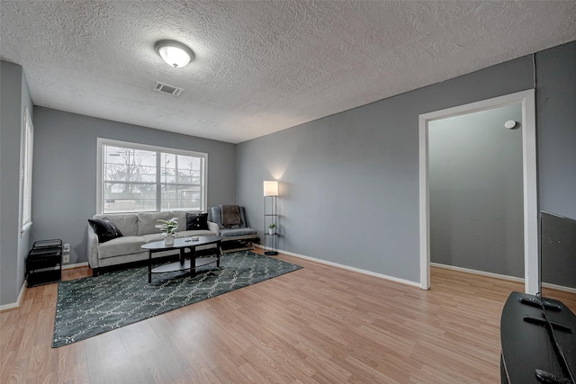 living room featuring a textured ceiling and light wood-type flooring