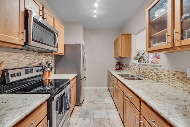 kitchen with stainless steel appliances, rail lighting, sink, and light stone counters