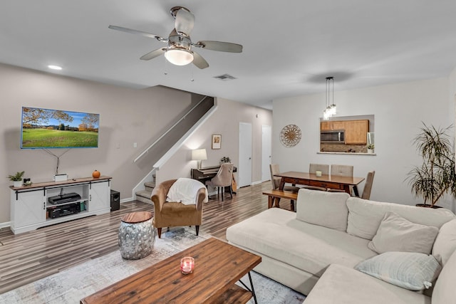 living room featuring wood-type flooring and ceiling fan