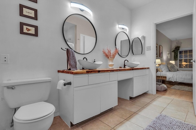 bathroom with vanity, toilet, and tile patterned flooring