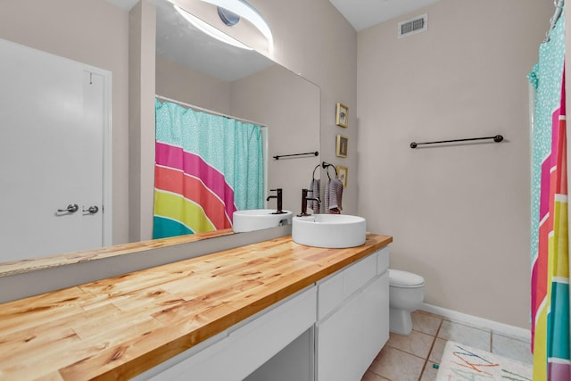 bathroom featuring vanity, tile patterned floors, and toilet