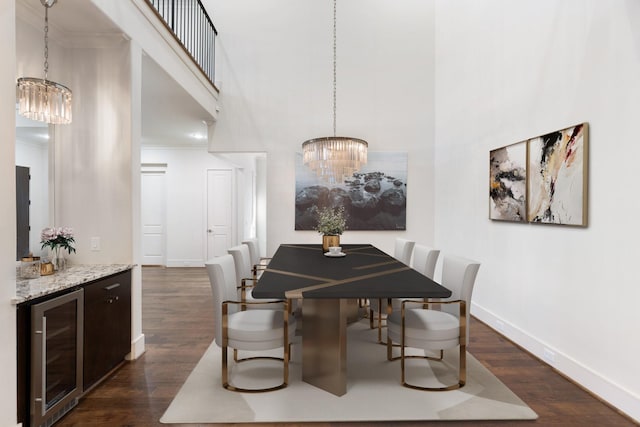 dining room with ornamental molding, dark hardwood / wood-style flooring, wine cooler, and a chandelier