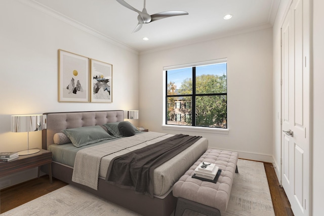 bedroom featuring wood-type flooring, crown molding, and ceiling fan