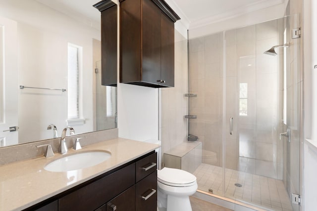 bathroom featuring vanity, a shower with door, ornamental molding, and toilet