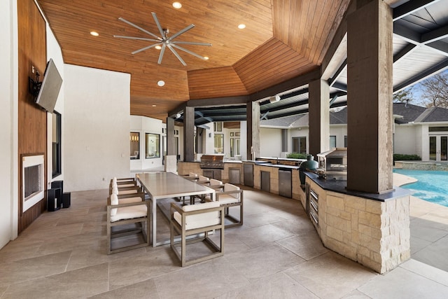 view of patio with area for grilling, sink, and ceiling fan