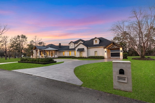 french country inspired facade with a yard and a garage