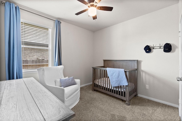 carpeted bedroom with multiple windows, a nursery area, and ceiling fan