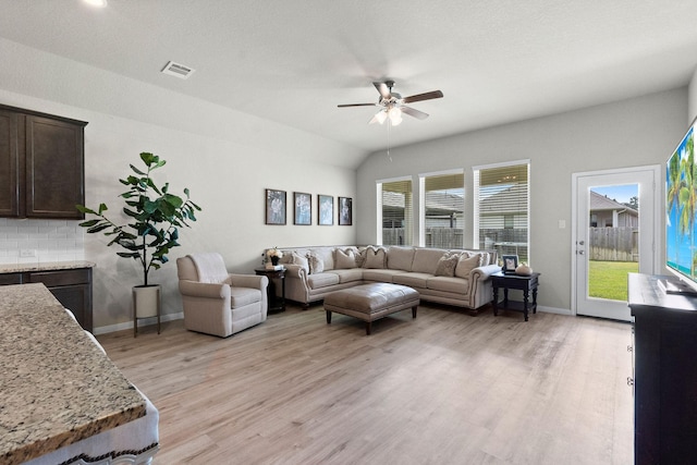 living room with ceiling fan, lofted ceiling, and light wood-type flooring