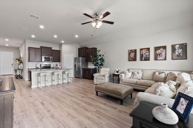 living room featuring ceiling fan and light hardwood / wood-style flooring