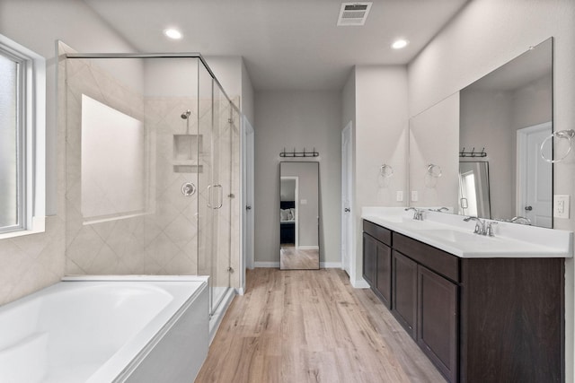 bathroom with vanity, hardwood / wood-style floors, and independent shower and bath