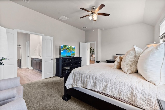 carpeted bedroom featuring lofted ceiling, ceiling fan, and ensuite bathroom