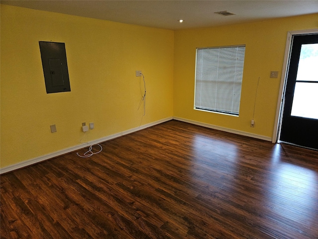 empty room featuring electric panel and dark hardwood / wood-style floors