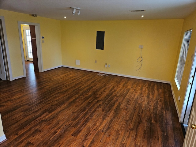 spare room featuring dark hardwood / wood-style flooring and electric panel