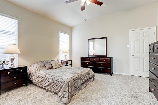 carpeted bedroom with ceiling fan, vaulted ceiling, and multiple windows