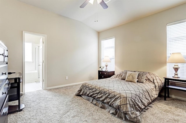 carpeted bedroom featuring ceiling fan, ensuite bath, and lofted ceiling