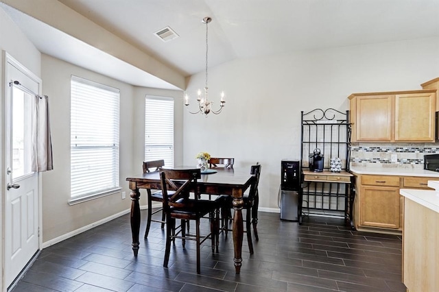 dining space with an inviting chandelier and vaulted ceiling