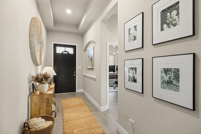 entryway with a tray ceiling and light hardwood / wood-style floors