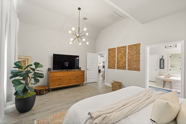 bedroom with connected bathroom, vaulted ceiling, light hardwood / wood-style flooring, and a notable chandelier