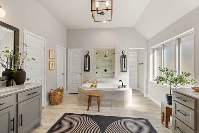 bathroom featuring a chandelier, vanity, independent shower and bath, and vaulted ceiling