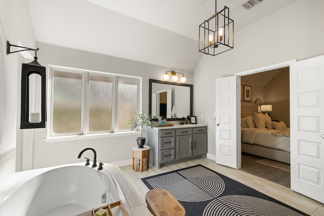 bathroom featuring a washtub, vanity, and vaulted ceiling