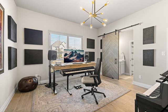 office with a barn door, a notable chandelier, and light hardwood / wood-style floors