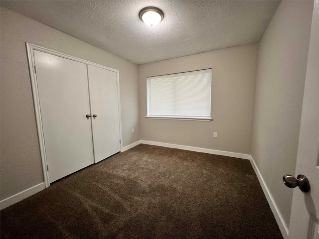 unfurnished bedroom featuring carpet floors, a closet, and a textured ceiling