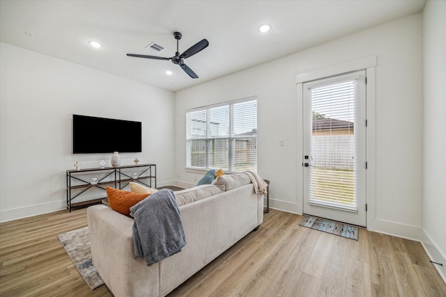 living room featuring light hardwood / wood-style flooring and ceiling fan