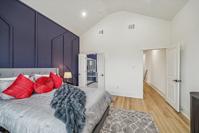 bedroom with hardwood / wood-style floors and high vaulted ceiling