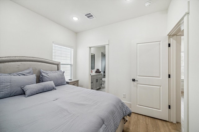 bedroom featuring light wood-type flooring and ensuite bathroom